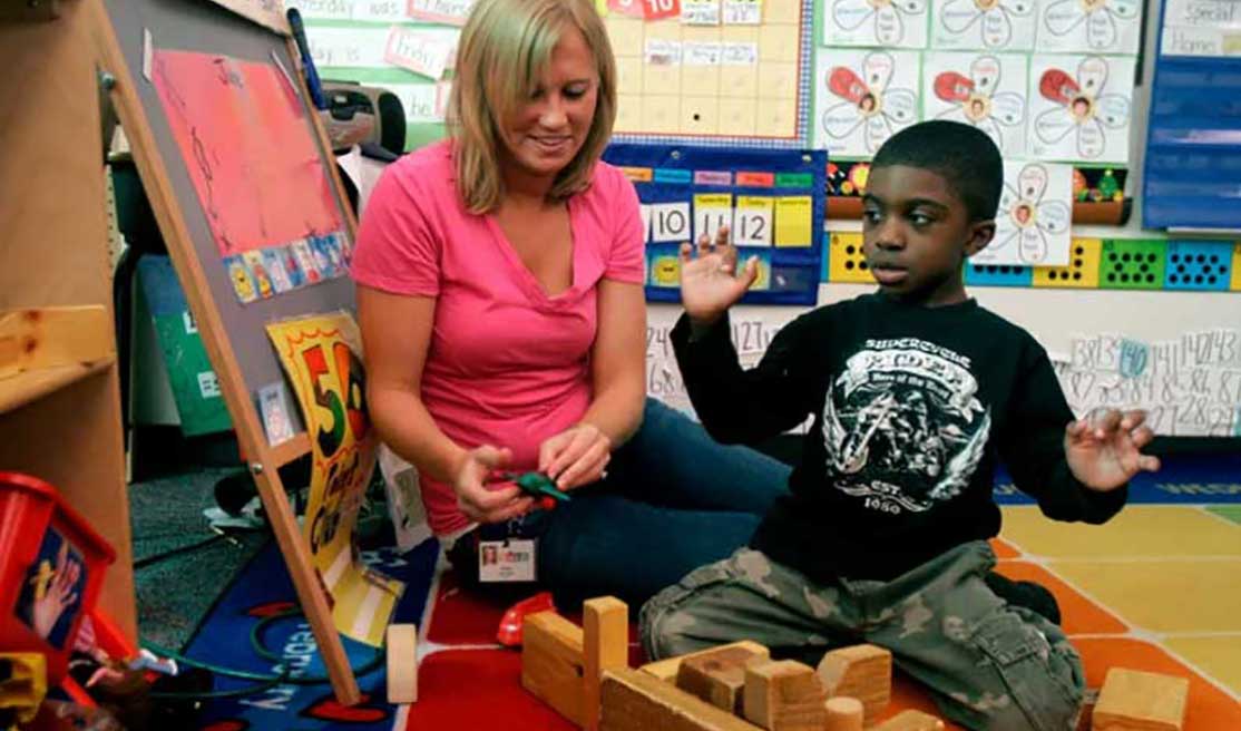 autistic child in classroom building blocks