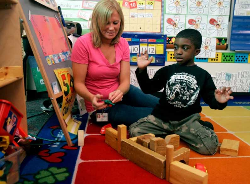 autistic child in classroom with building blocks