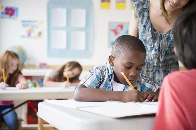 autistic child in classroom writing