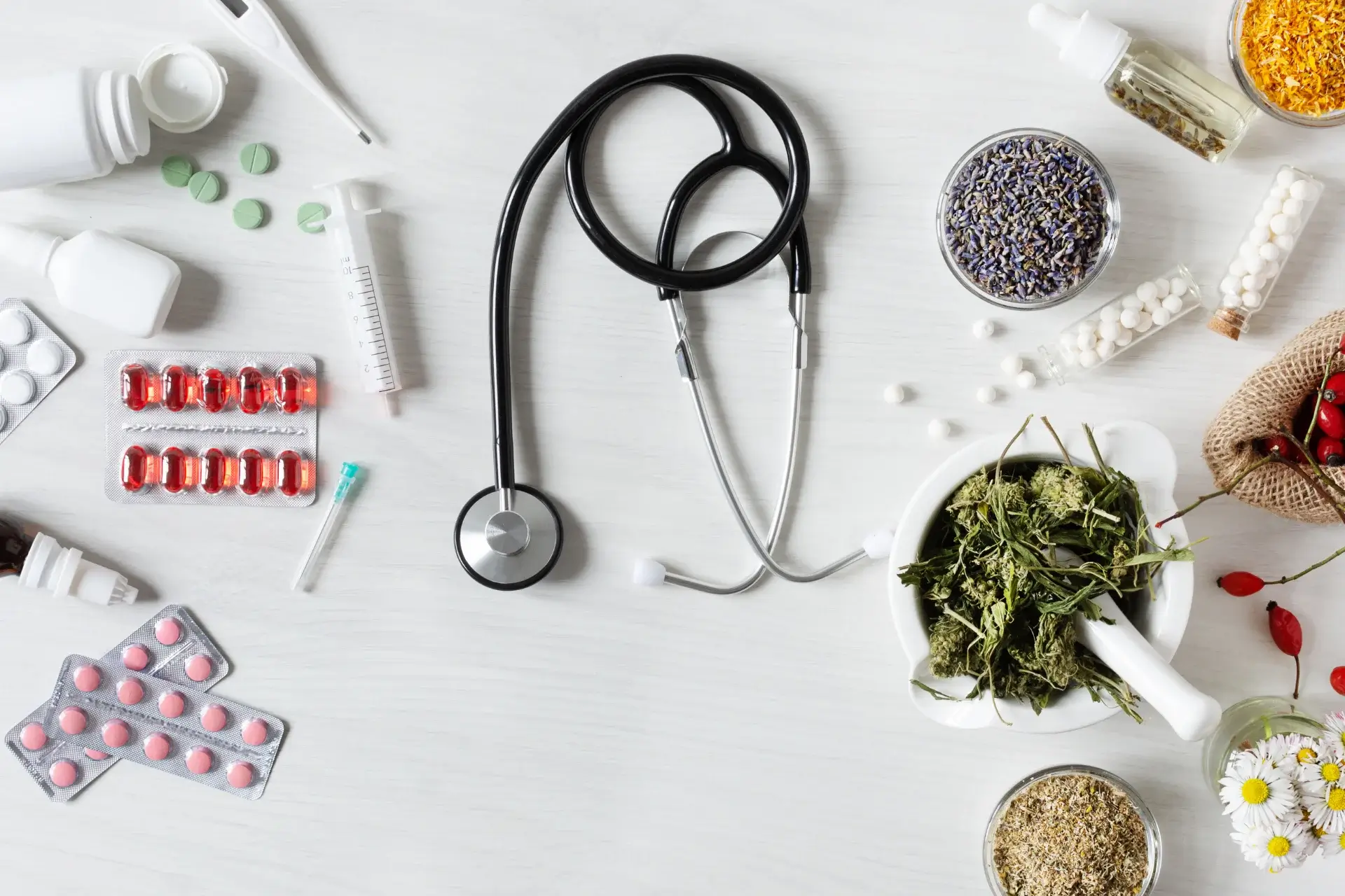 A stethoscope and some pills on top of the table.